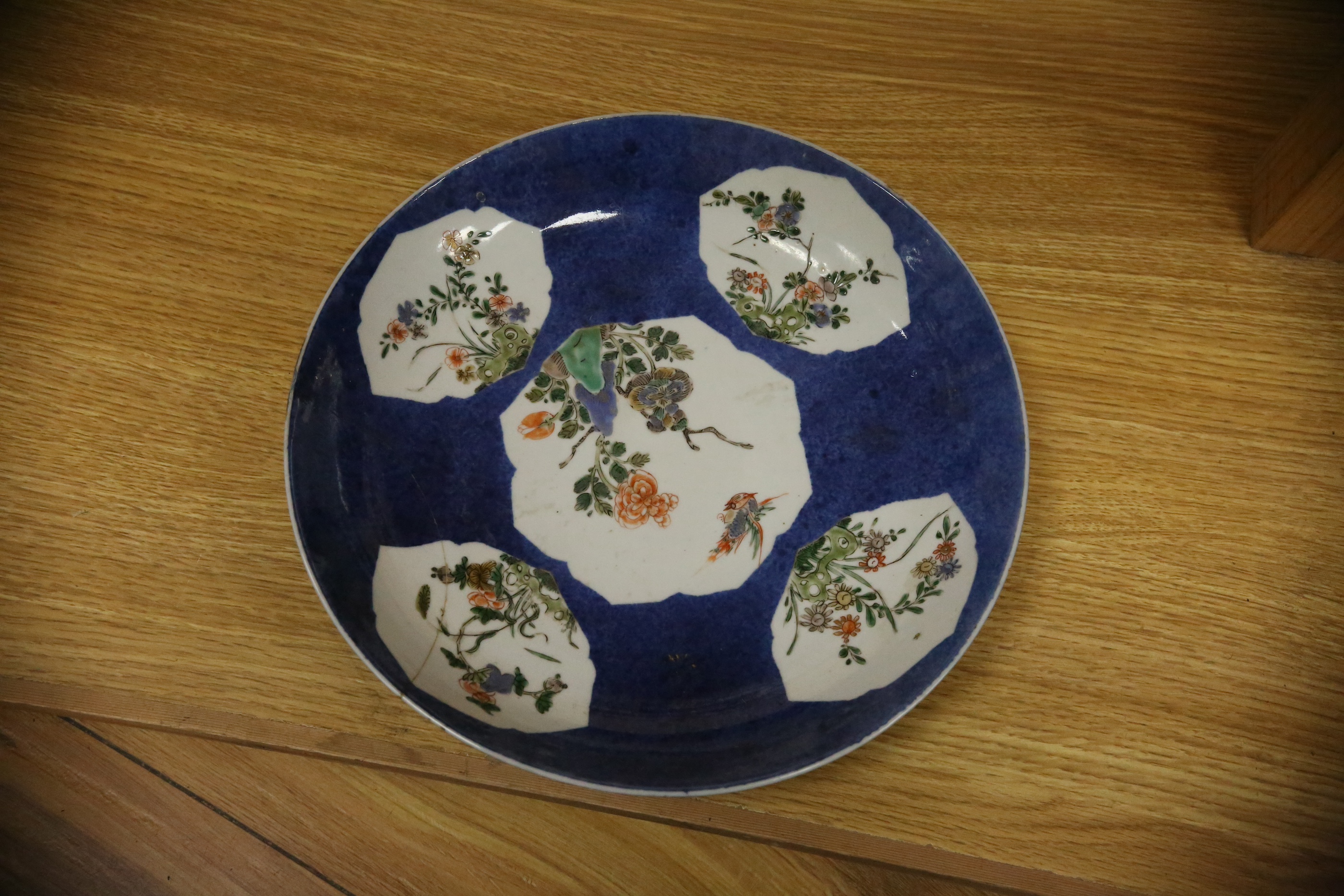 A Chinese famille verte powder blue ground bowl and a similar dish, both Kangxi period, 27.5cm diameter. Condition - dish poor, bowl fair